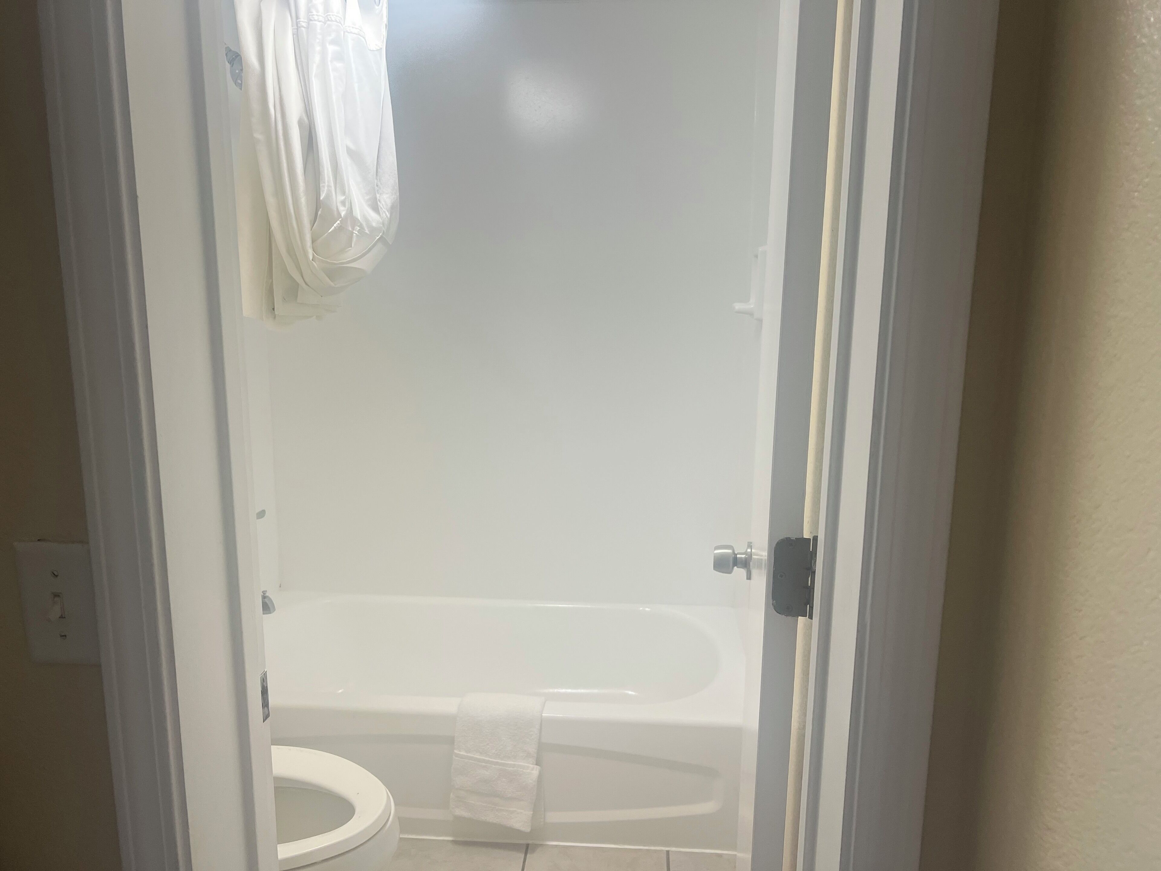 Un baño con una bañera blanca, un inodoro y una cortina de ducha.