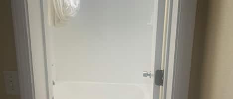 Un baño con una bañera blanca, un inodoro y una cortina de ducha.