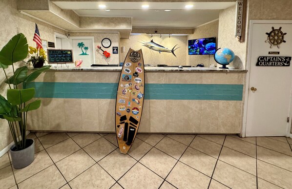 Welcome to the Captain's Quarters, where a surfboard-adorned reception desk greets guests.