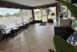 Enjoy dining in a stylish space with a central table, comfortable chairs, and a view of the street outside.