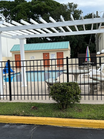 Una piscina al aire libre, sillones reclinables de piscina