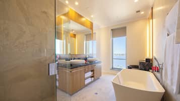 Ein modernes Badezimmer mit einer freistehenden Badewanne, einem Doppelwaschtisch mit zwei Becken und einem großen Spiegel.