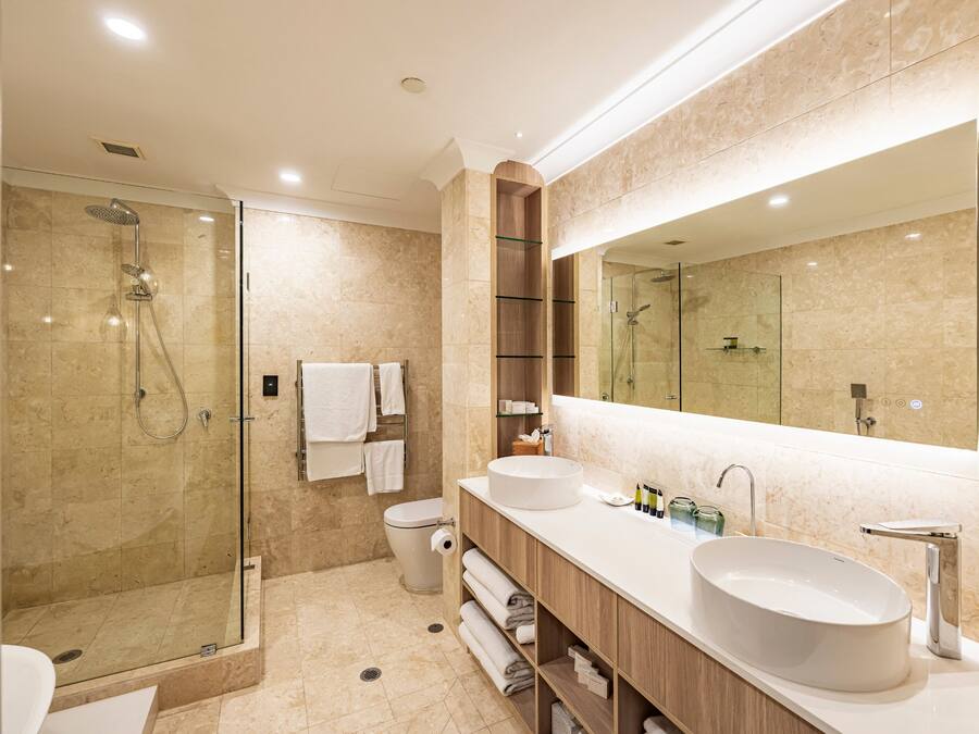 A modern bathroom with a glass-enclosed shower, a double sink vanity, and a large mirror.