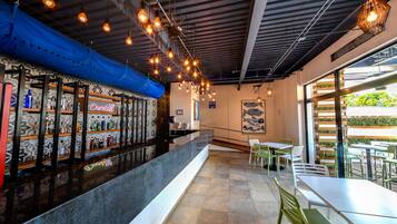 Interior de un restaurante con barra, asientos y vistas amplias a través de grandes ventanales.