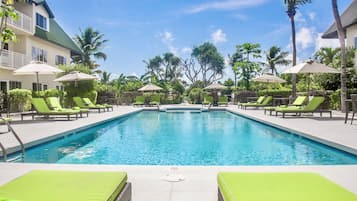 Alberca al aire libre, sombrillas en la alberca y camastros