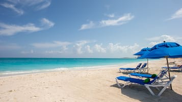 Relax on the beach with comfortable sun loungers and umbrellas.