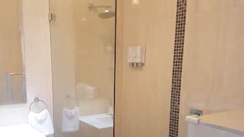A modern bathroom with a glass-enclosed shower, a white sink, and a mirror.