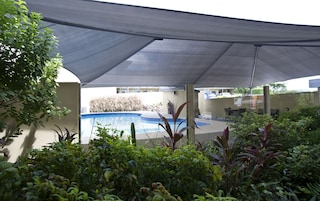 Una piscina al aire libre, sillones reclinables de piscina