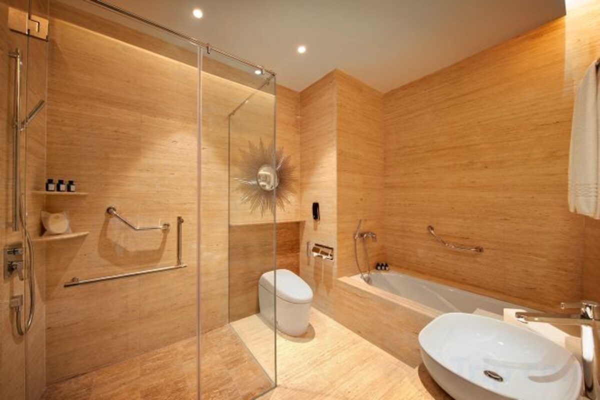 A modern bathroom with a glass-enclosed shower, a white toilet, and a freestanding bathtub.