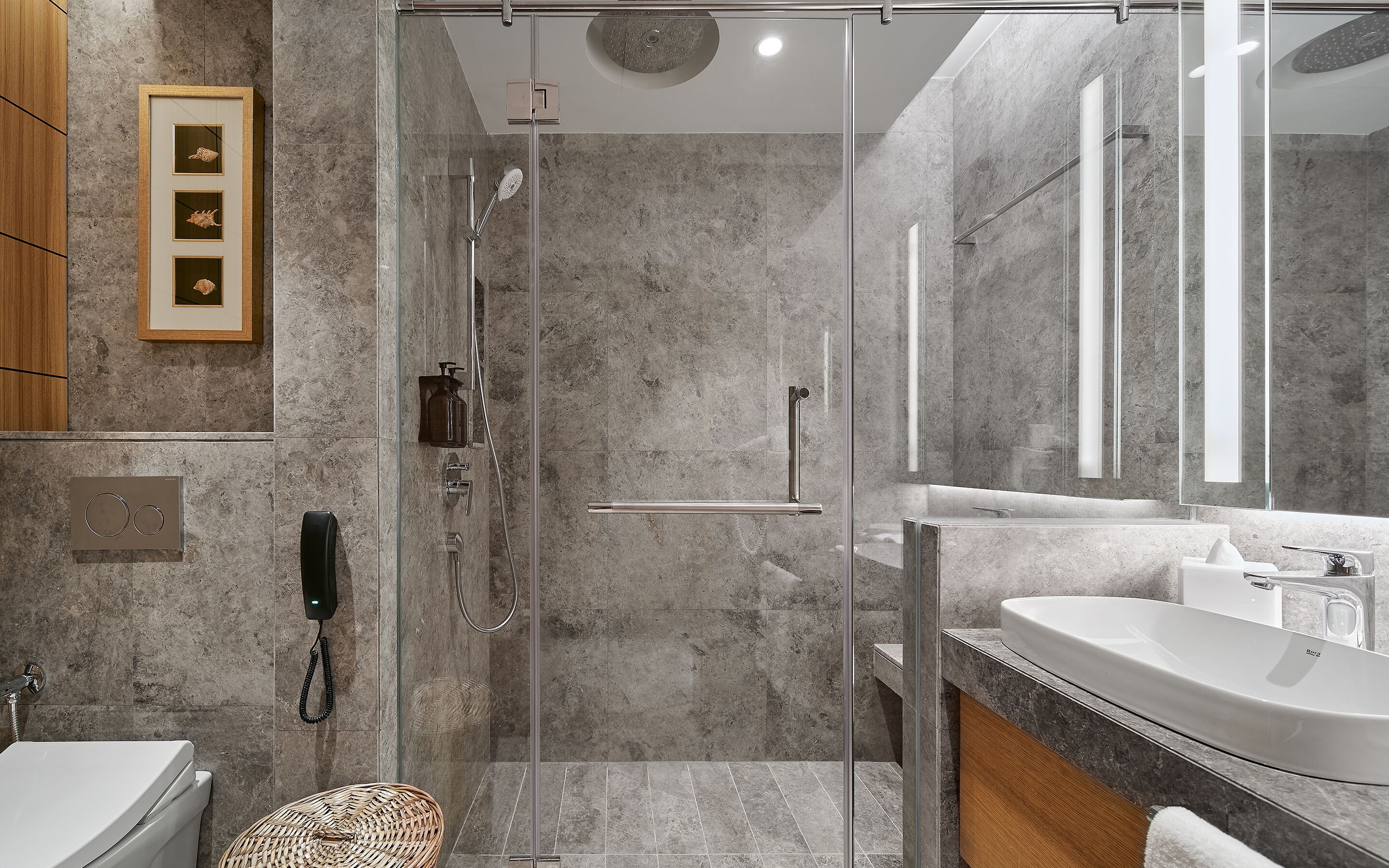 Een moderne badkamer met een douchecabine van glas, een wastafelmeubel met een grote spiegel en een toilet.