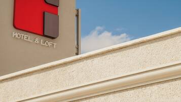 A hotel sign with a red and grey logo and the text "HOTEL & LOFT".