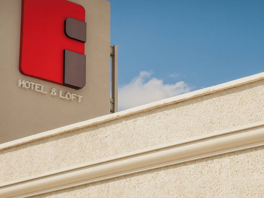 A hotel sign with a red and grey logo and the text "HOTEL & LOFT".