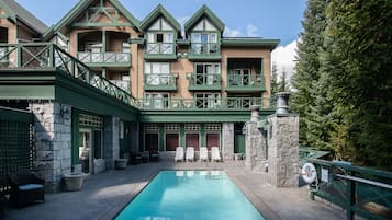 Een buitenzwembad en ligstoelen