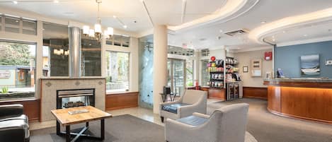 A spacious lobby with a fireplace, seating area, and a reception desk.