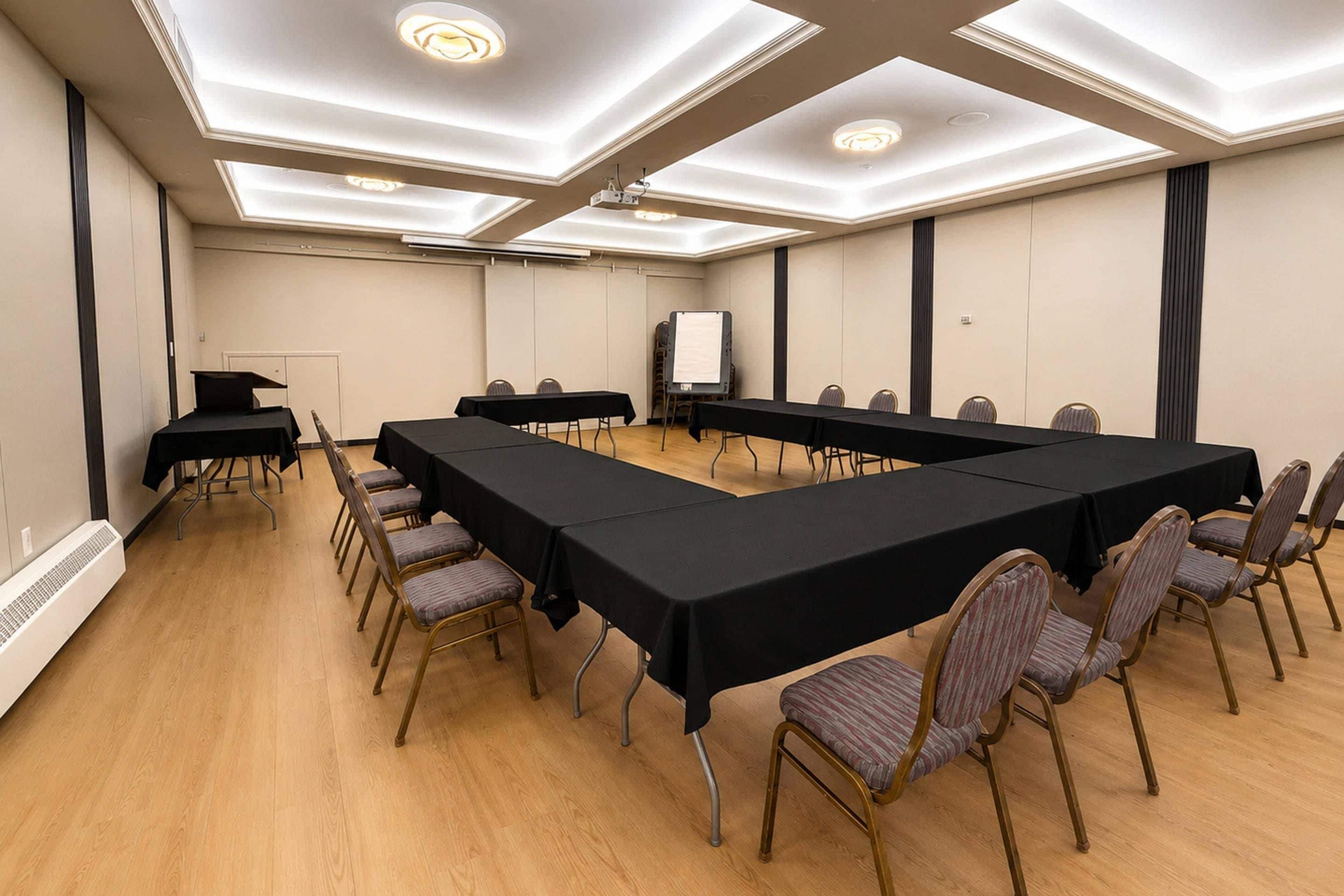A conference room with a long table, chairs, a projector, and a whiteboard.