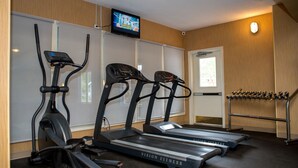 A fitness room with treadmills, a stationary bike, and a TV screen. - Maritime Inn, an Ascend Collection Hotel (Port Hawkesbury)