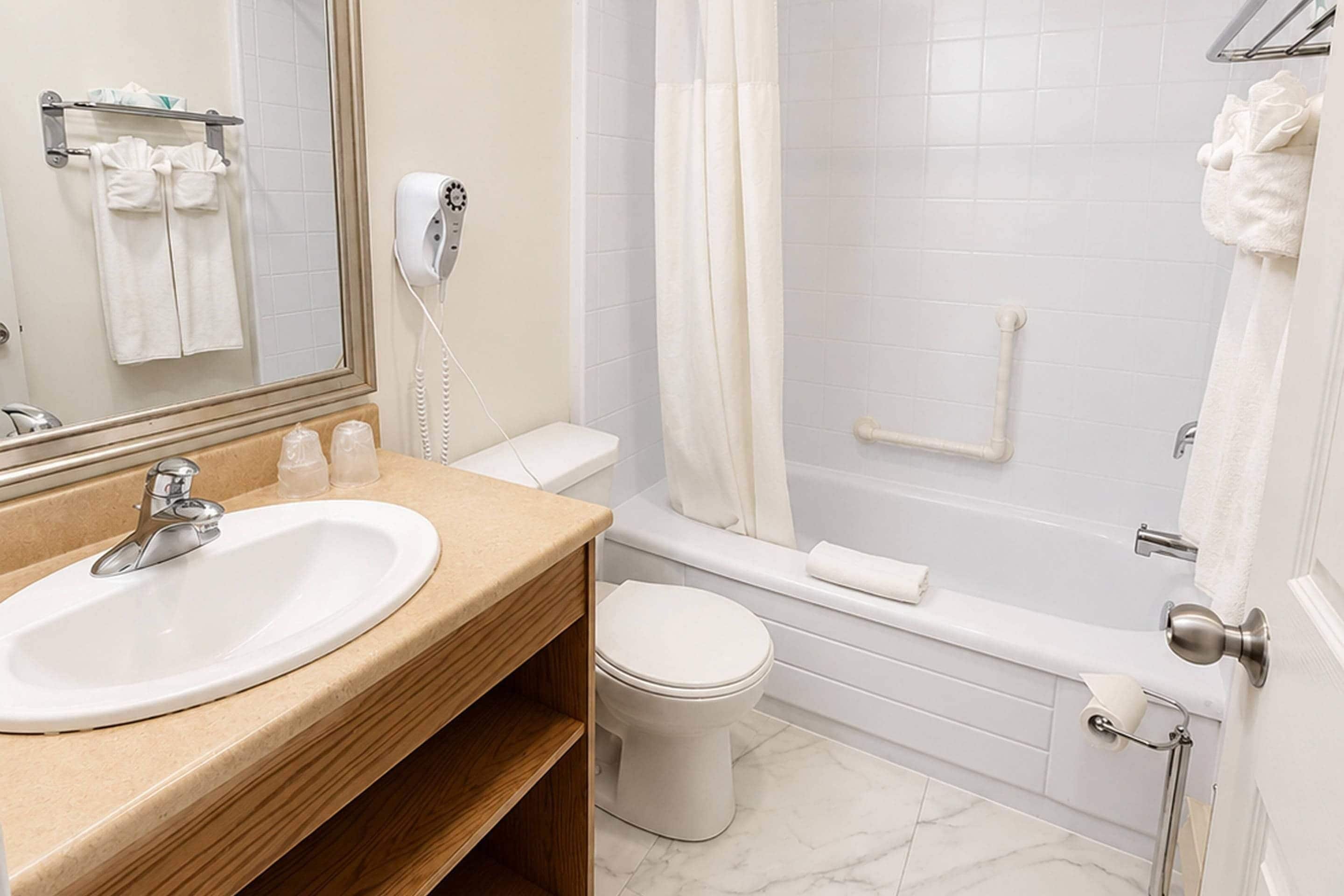 Un baño con lavamanos, inodoro y bañera.