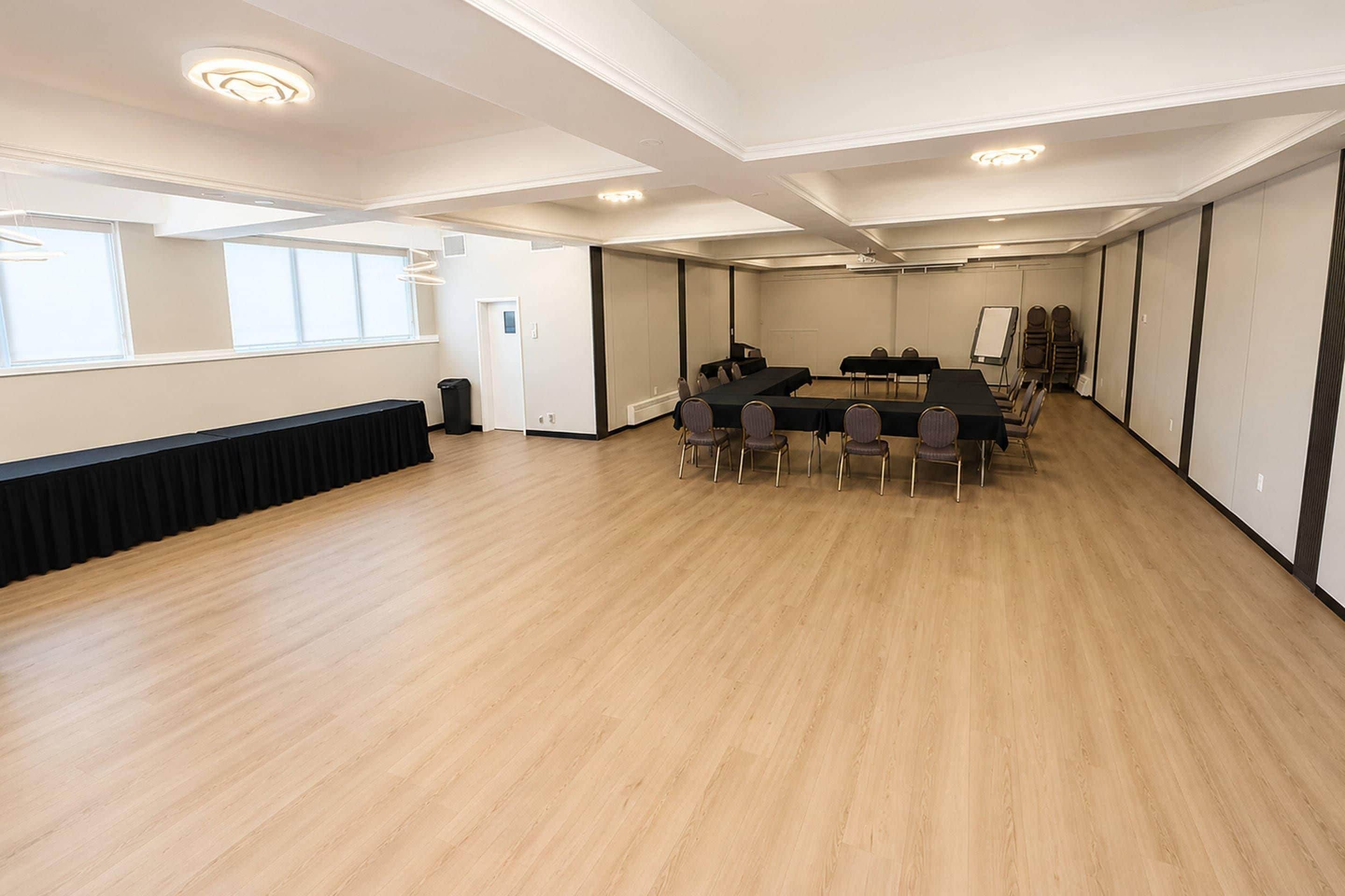 Un salón de conferencias con una larga mesa, sillas y una pizarra.