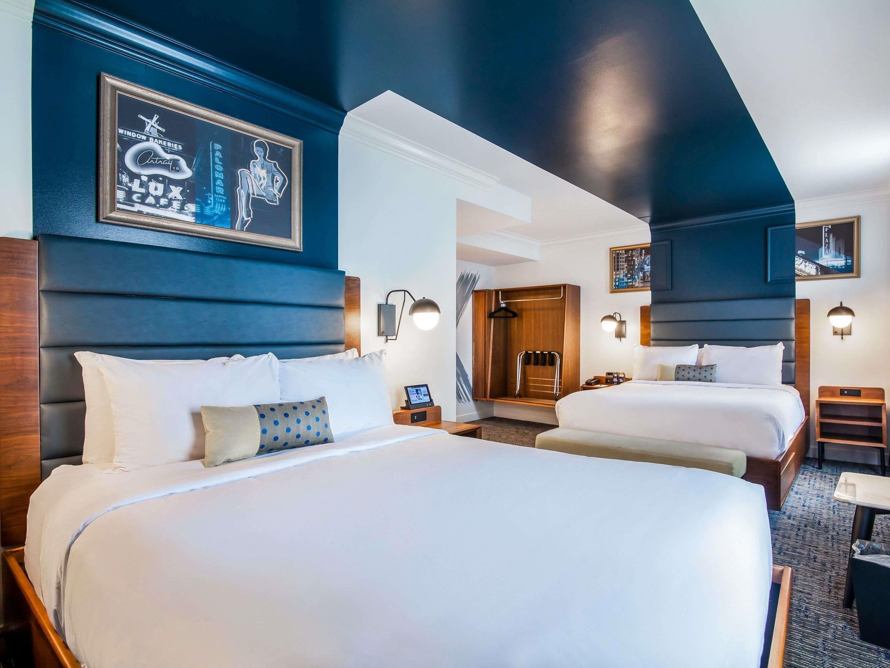 Une chambre d’hôtel avec deux lits, une douche et une vue sur la ville.