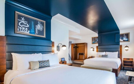 A hotel room with two beds, a shower, and a view of the city.