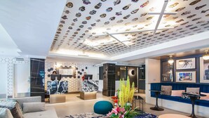 A modern lobby with a reception desk, seating area, and a ceiling with a unique pattern. - Hotel Belmont Vancouver - MGallery Collection (Vancouver)