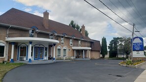 A hotel with a brick facade, a covered entrance, and a sign indicating a pool is open. - Best Value Inn & Suites Parry Sound (Parry Sound)