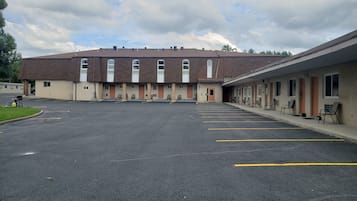 Un motel con aparcamiento y varias habitaciones.