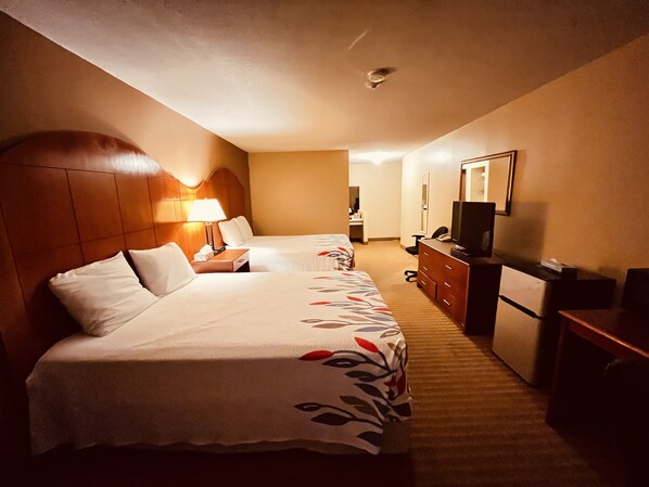 A hotel room with two beds, a desk, a dresser, a television, and a mirror. - Best Value Inn & Suites Parry Sound (Parry Sound)