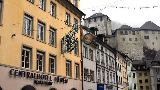 A building with a sign for "CENTRALHOTEL LÖWEN RESTAURANT" and a street lamp with a decorative design. - Central Hotel Löwen (Feldkirch)