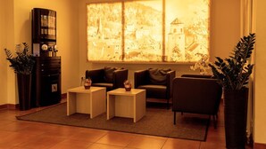 A living room with a large window, sofas, a coffee table, and a cabinet. - Central Hotel Löwen (Feldkirch)