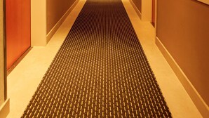 A hotel hallway with a carpeted floor, doors on both sides, and recessed lighting. - Central Hotel Löwen (Feldkirch)