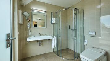 Ein modernes Badezimmer mit einer Duschkabine aus Glas, einem weißen Waschbecken und einer Toilette.