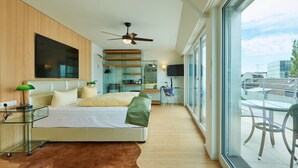 Ein modernes Schlafzimmer mit einem Bett, einem Schreibtisch und einem großen Fenster.