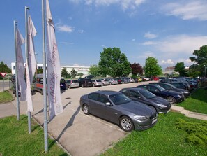 Ein Parkplatz mit mehreren Autos und Flaggen.