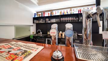 A bar area with a newspaper, a beer tap, and a soda tap.