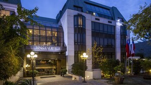 A hotel with a modern architectural design, featuring large glass windows and a well-lit entrance. - Hotel Bonaparte Boutique (Santiago)