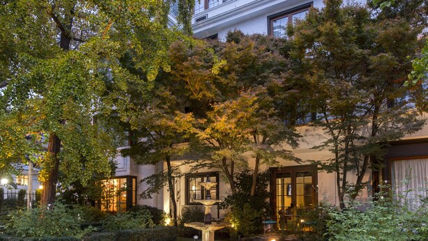 A courtyard with a fountain, surrounded by trees and lavender plants. - Hotel Bonaparte Boutique (Santiago)
