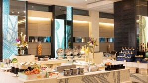 A buffet setup with various food items and dishes, a large mirror, and decorative elements. - Hengshan Garden Hotel (Shanghai)