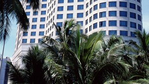 A high-rise hotel with a curved facade, multiple floors, and a prominent signage at the top. - Hainan Junhua Haiyi Hotel (Haikou)