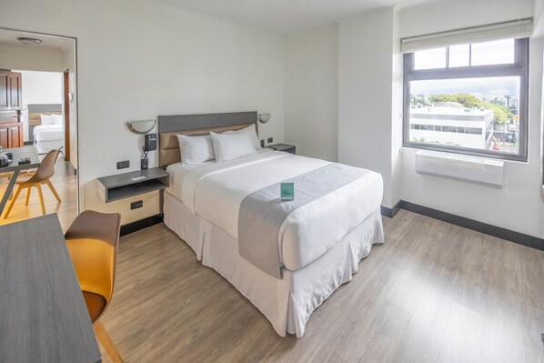 A hotel room with a bed, bedside tables, a desk, and a chair. - Parque del Lago Boutique Hotel (San José)