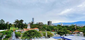 Un paisaje urbano con una iglesia destacada, una combinación de edificios modernos y tradicionales, y montañas al fondo.