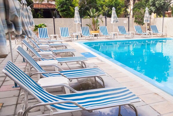 Piscine extérieure, parasols de plage, chaises longues