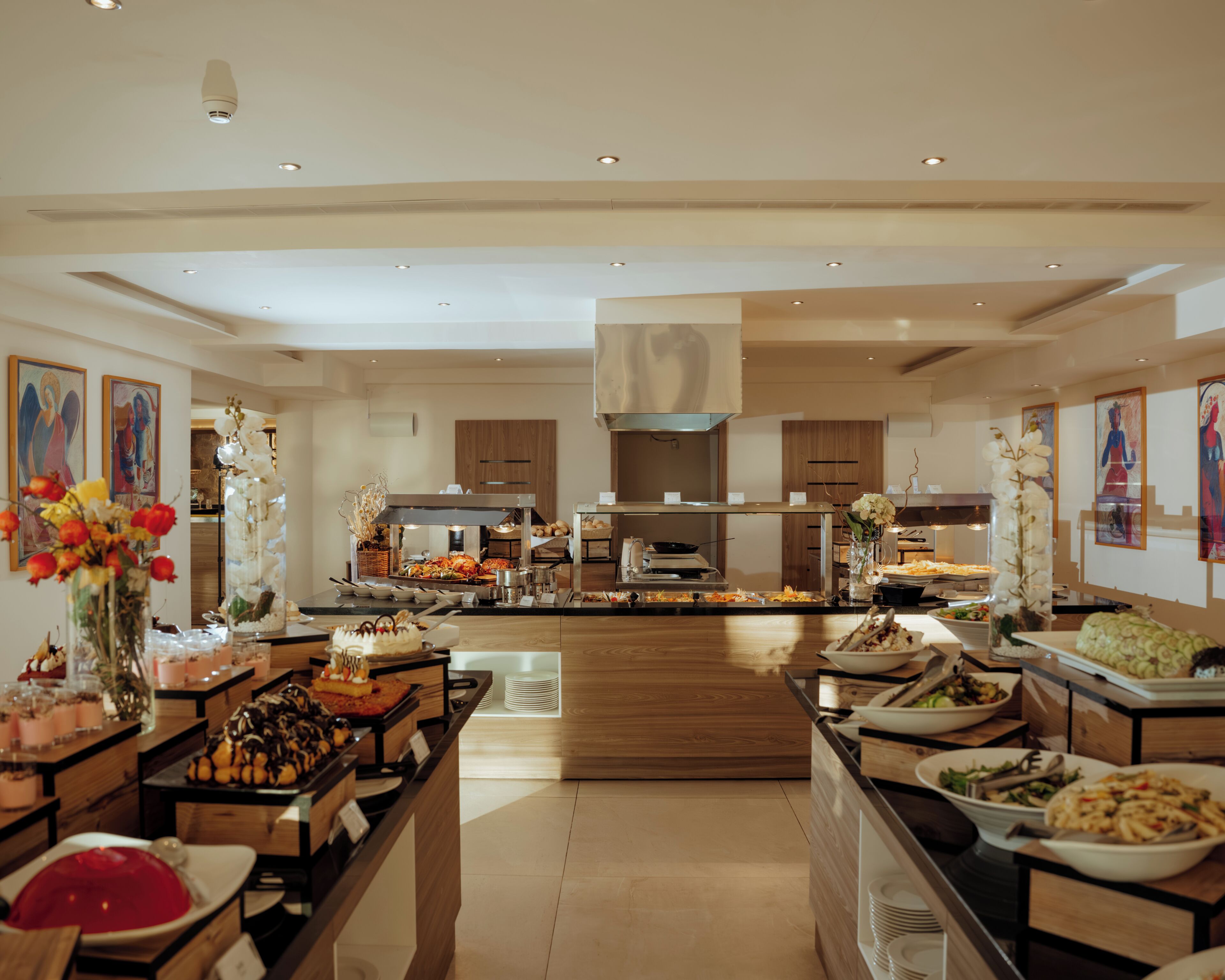 Et rummeligt buffetområde med flere madstationer og en central bod.