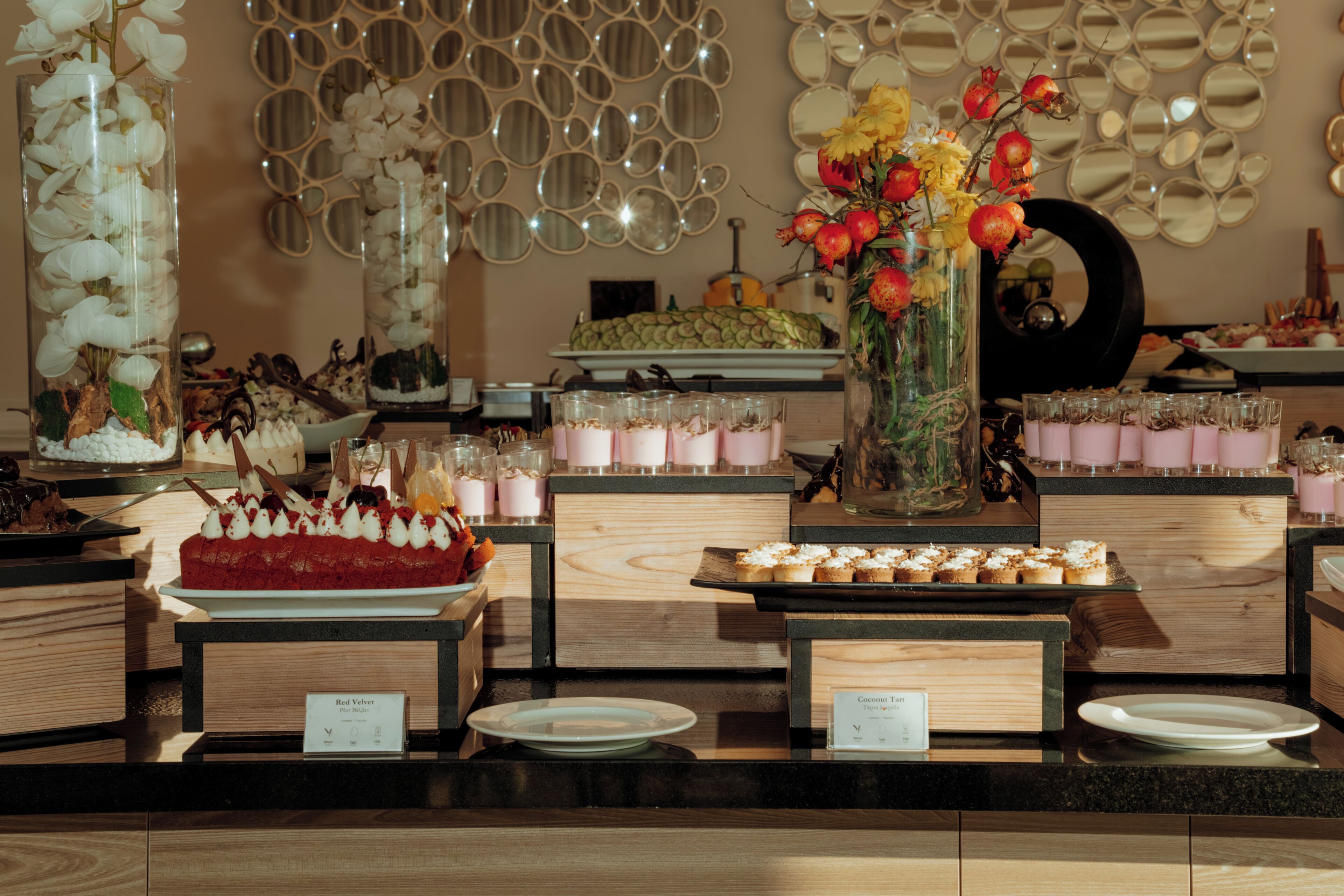 Buffet amb diferents plats i una paret decorativa amb miralls.