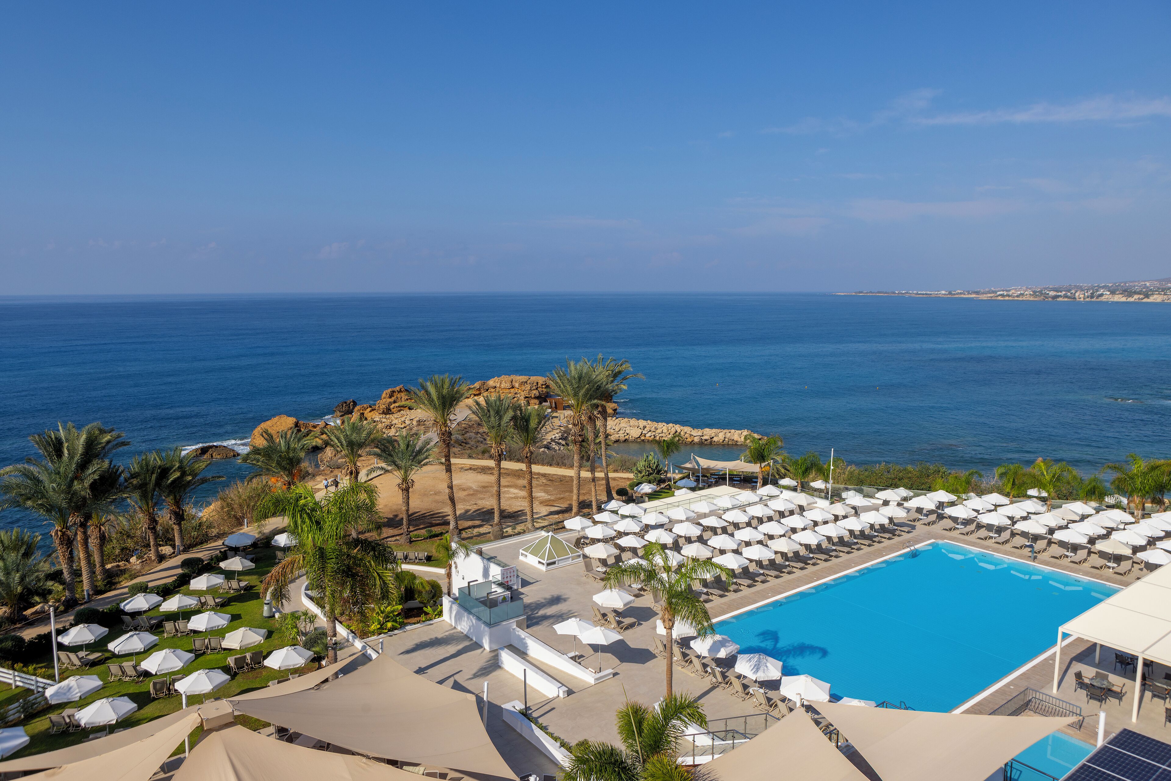 A resort with a pool, beach, and ocean view.