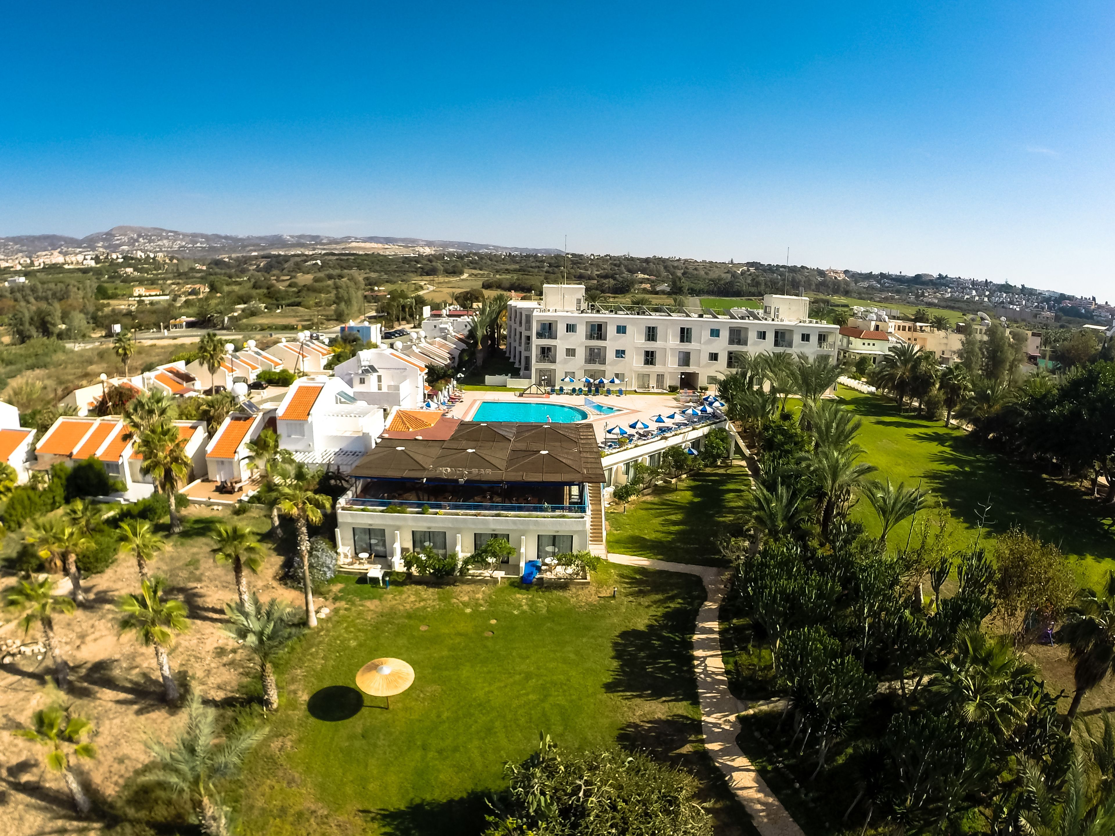 Ein Resort mit mehreren Gebäuden, einem Schwimmbad und einem gepflegten Rasen.