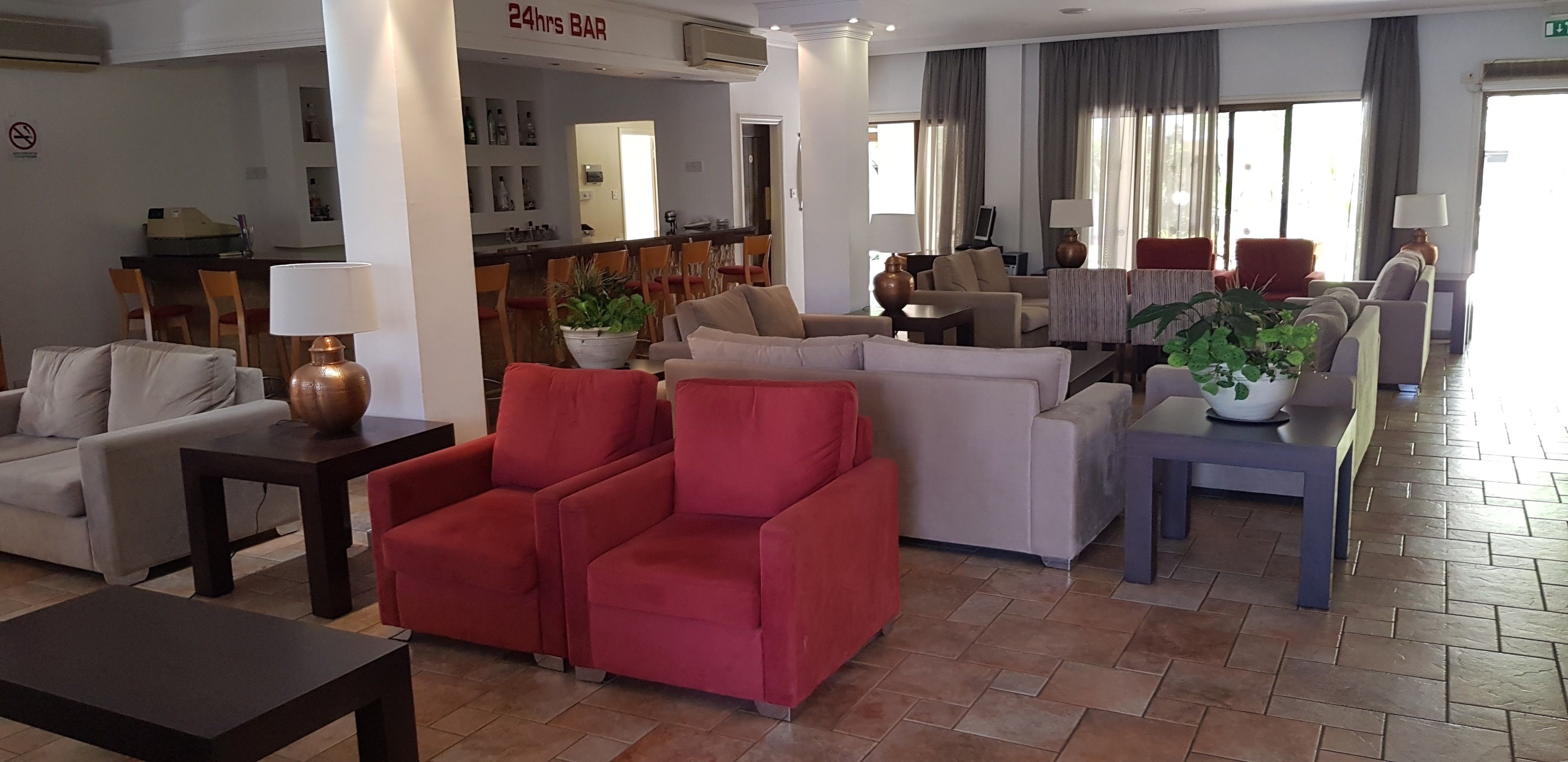 A spacious lobby with a 24hr bar, comfortable seating areas, and a dining space.