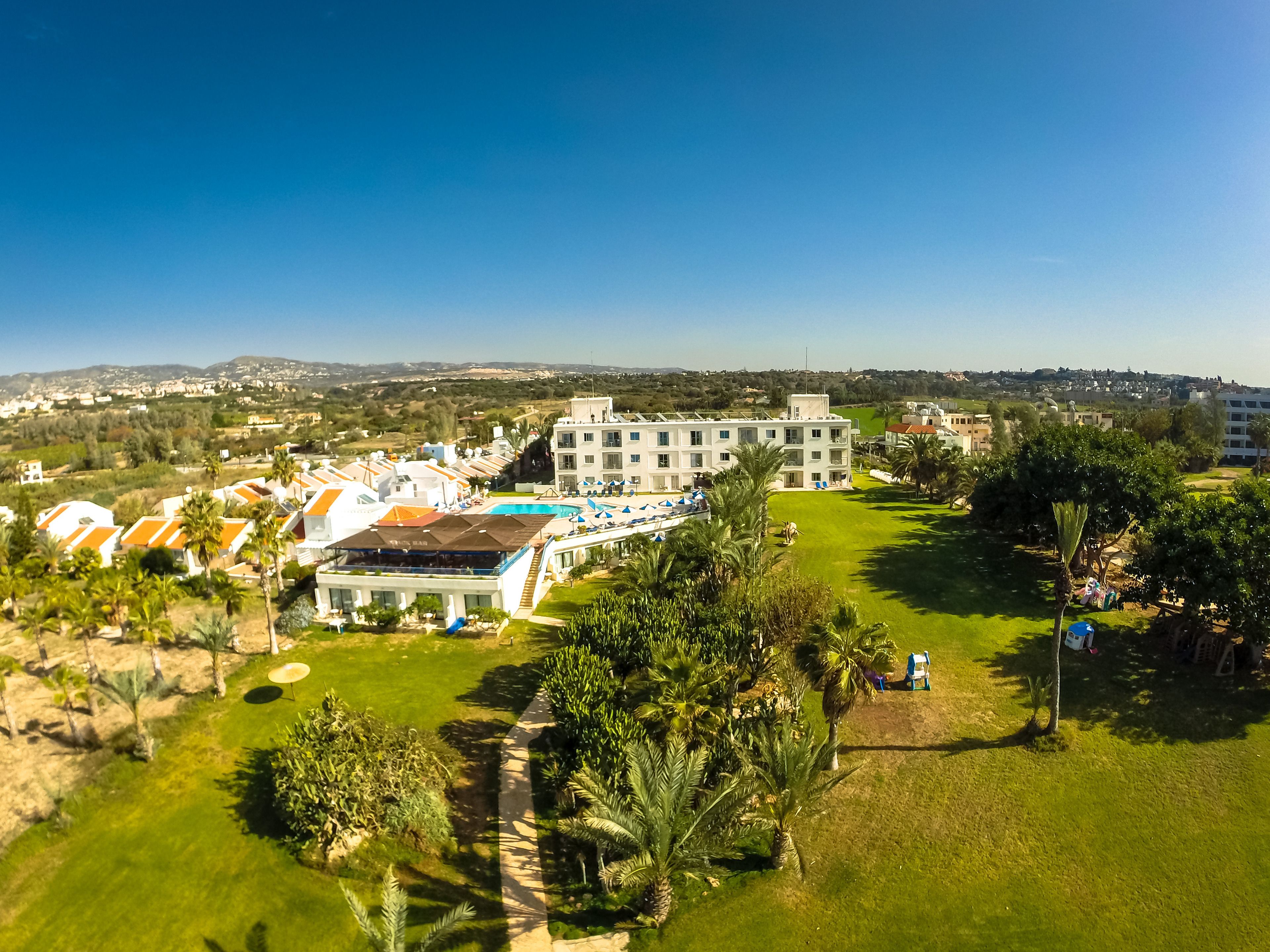 Ein Resort mit mehreren Villen, einem Schwimmbad und einem großen Gebäude mit Balkonen.