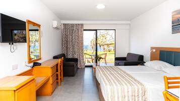 A hotel room with a bed, desk, and seating area.