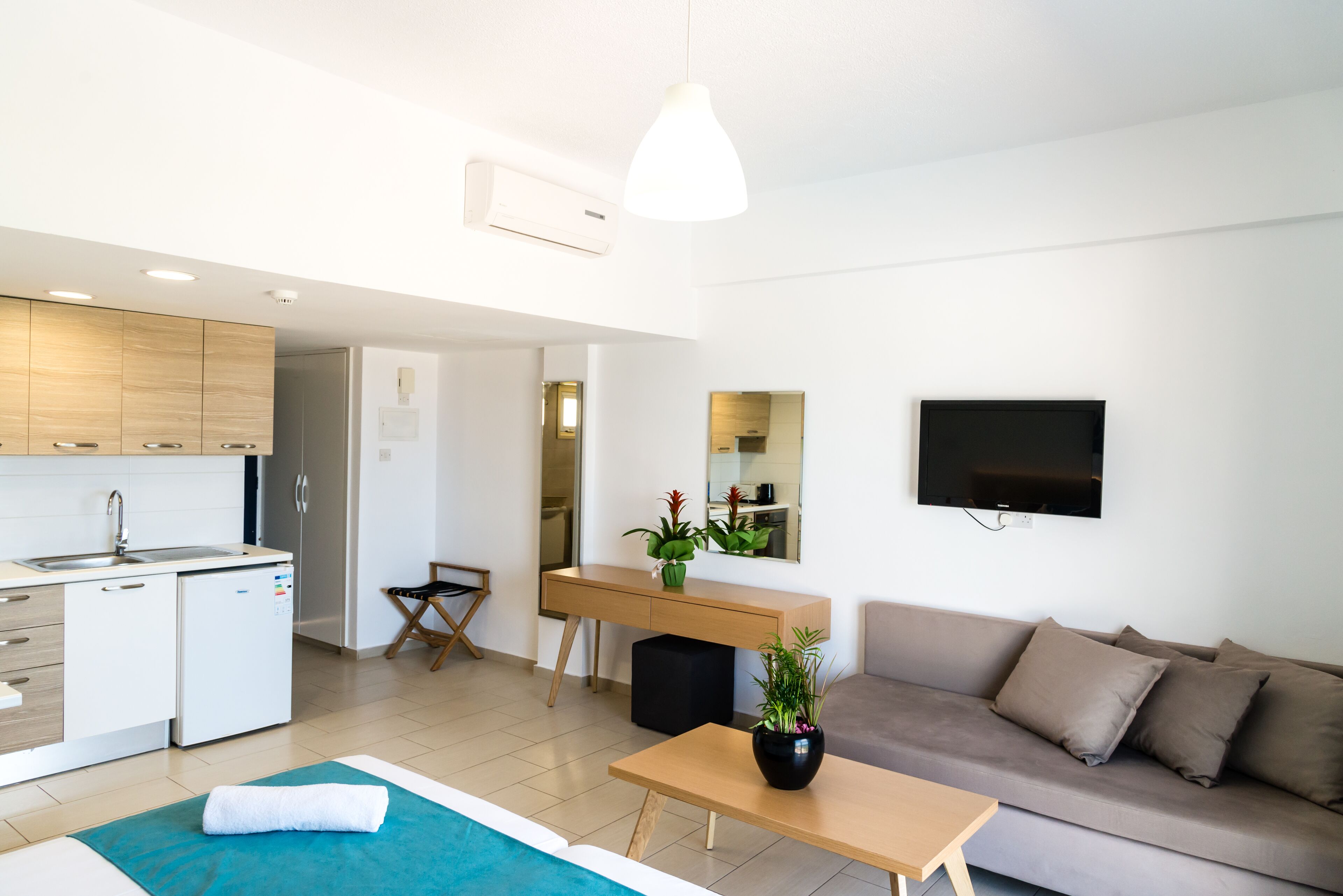 Un salon moderne avec un canapé, une table basse et un téléviseur fixé au mur.